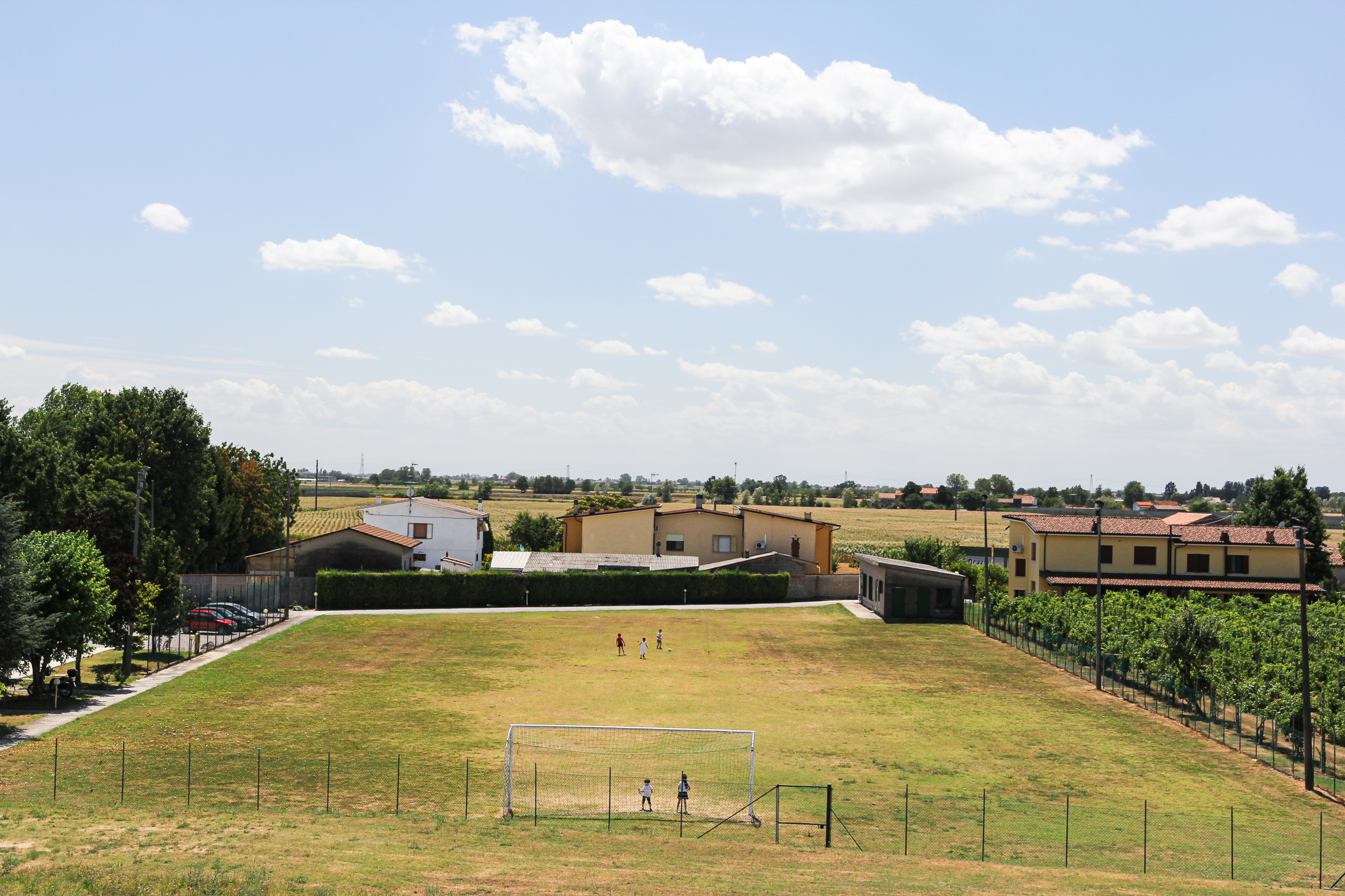 Fußballplatz am Ortsrand, dahinter die Ebene ohne Ende